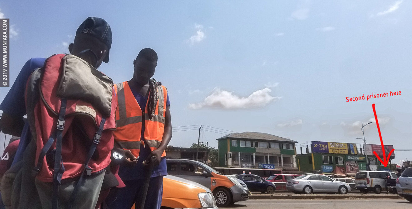 Ghana Prisoner Holding A Shovel and Panhandling for Money on the Street of Accra, Ghana.