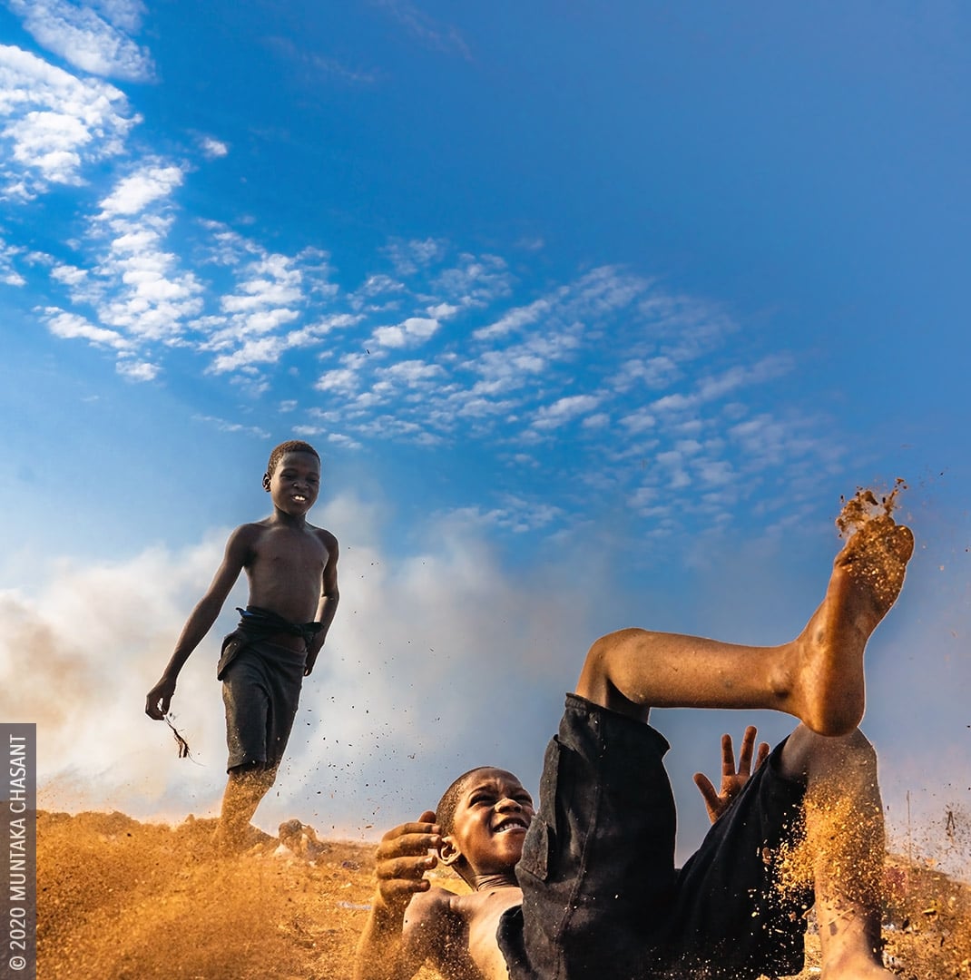 Agbogbloshie slum children playing in sawdust. Captured at Agbogbloshie, Ghana. © 2020 Muntaka Chasant
