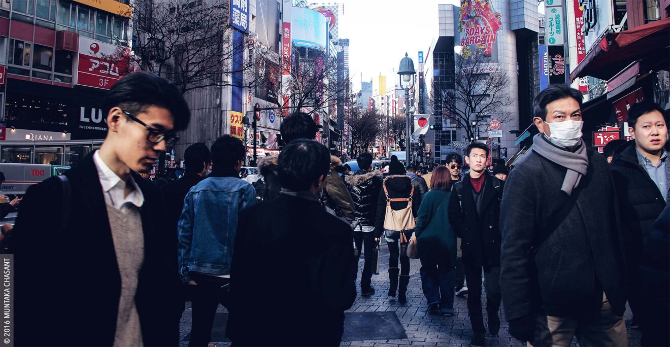 Tokyo Street Photography: Shibuya, Tokyo, Japan. Near the Shibuya intersection, a scramble crossing in front of the Shibuya station. The Shibuya station is one of the busiest commuter rail stations in the world. The iconic Shibuya scramble crossing is often rated the busiest pedestrian crossing in the world, sometimes accommodating more than 2000 people at a time. © 2016 Muntaka Chasant