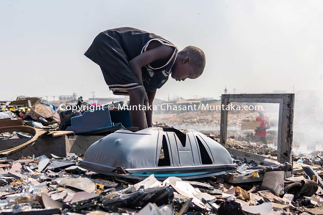Kwadwo, 9, recovers iron from CRT-TVs on a CRT glass-strewn dumpsite. Copyright © Muntaka Chasant