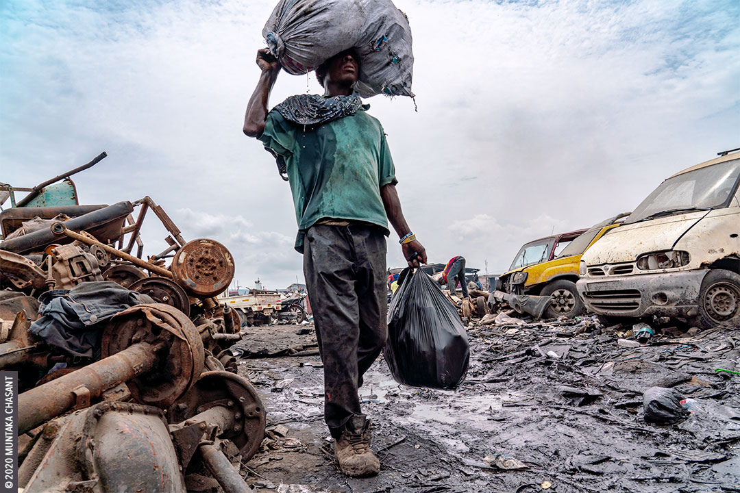 Urban Suffering: Urban poor man carries a plastic sack on his head with liquid dripping from it in Accra, Ghana. 41% of people in Africa live in extreme poverty, with the World Bank estimating that nearly 9 out of every 10 people in extreme poverty will be living on the continent by 2030. © 2020 Muntaka Chasant