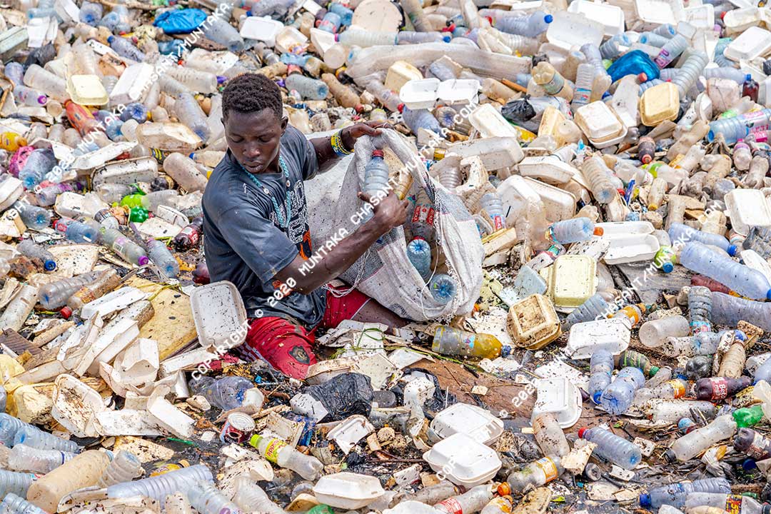 Plastic pollution in Ghana: An urban poor man collects plastic bottles in the heavily polluted Korle Lagoon in Accra, Ghana's capital city. Plastic waste collection is a source of livelihood for many urban poor in Ghana. The Korle Lagoon links to the Gulf of Guinea, the northeasternmost part of the tropical Atlantic Ocean. Copyright © 2020 Muntaka Chasant
