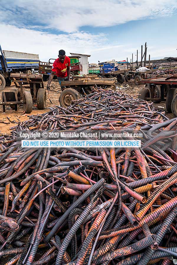 Agbogbloshie in September 2020: Photo of an urban poor man arranging copper materials from recycled heliax coaxial cables. The wires had been burned in the open just by the Korle Lagoon. Copyright © 2020 Muntaka Chasant