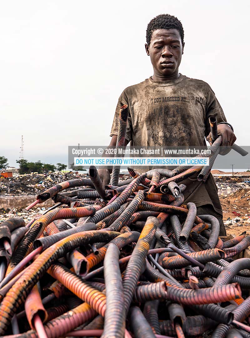 Agbogbloshie: Urban poor man arranges copper from recycled heliax coaxial cables at Agbogbloshie, Ghana. Copyright © 2020 Muntaka Chasant.