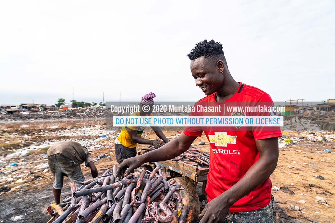 Agbogbloshie: Nicknamed 'Zongo boy,' urban poor man is happy they have copper from recycled heliax cables. 'Zongo boy' is a local musician. Copyright © 2020 Muntaka Chasant