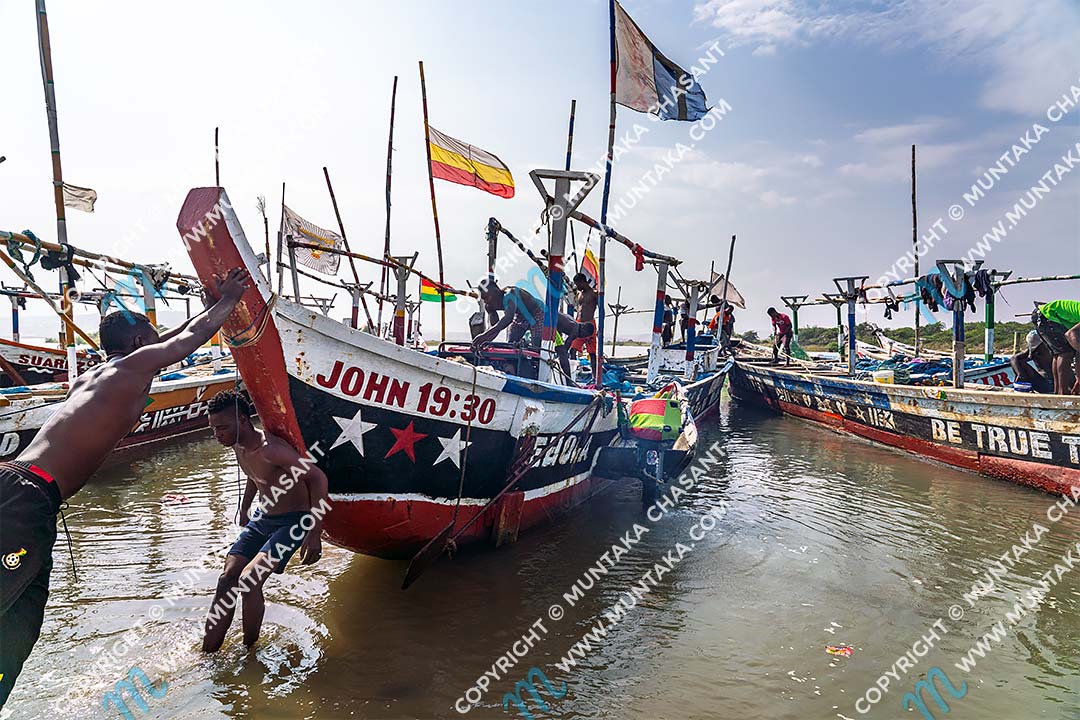 Fishing in Ghana: Motorized artisanal canoe engaged in light fishing is setting out to sea (Gulf of Guinea). They had just loaded up portable generators that will be used to power up light bulbs to attract shoals of fish. It is a destructive fishing method and illegal under Ghana's fisheries laws. Accra, Ghana. Copyright © 2020 Muntaka Chasant