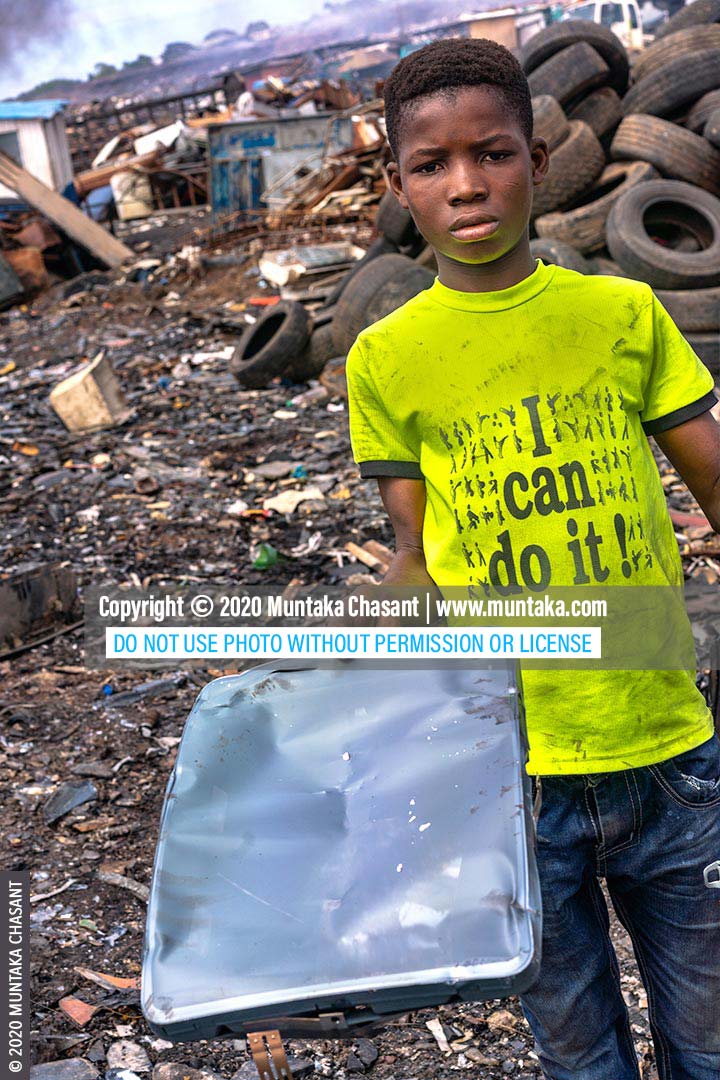 CRT TV Shadow Mask: 14-year-old Bright Ankrah with ‘I can do it’ on the front of his t-shirt had just recovered a shadow mask from an old CRT TV at Agbogbloshie, Ghana. He used his bare hands and stones to separate the panel and funnel glass from the precious metals inside the old television set. © 2020 Muntaka Chasant