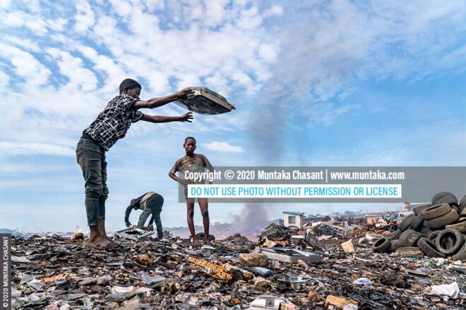 Child labour and electronic waste: Agbogbloshie, Ghana — Osei, 15 years old, is smashing an old CRT TV against a rock to reclaim the shadow mask and other iron materials inside. Many children are involved in the informal recycling of e-waste at Agbogbloshie. © 2020 Muntaka Chasant