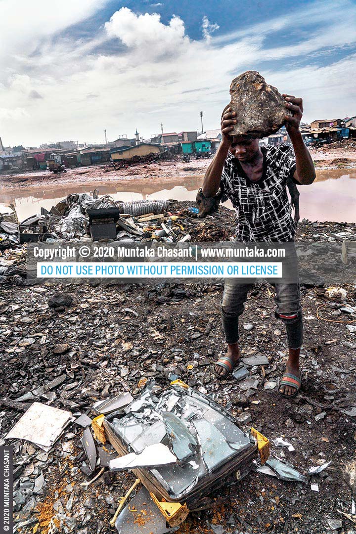 Child labour in Africa: A 15 years old boy at Agbogbloshie, Ghana, is using a stone to break apart an old CRT TV to recover the iron materials inside. Iron scrap sold for around $0.15 per kilo at Agbogbloshie in May 2020. About 31.5 million children in Africa are in hazardous child labour, according to ILO global estimates. © 2020 Muntaka Chasant