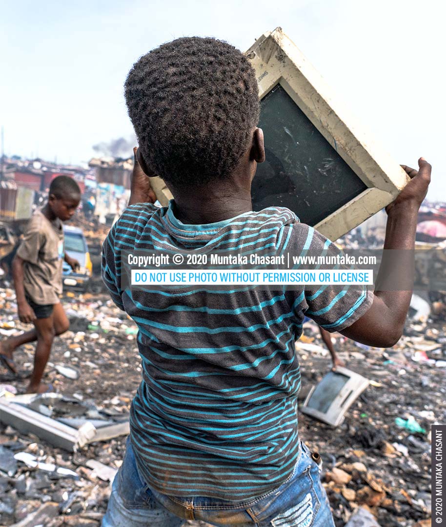 E-waste miner: An 11-year-old Agbogbloshie e-waste miner is about to smash an old CRT computer monitor against a rock to reclaim the iron materials inside. © 2020 Muntaka Chasant
