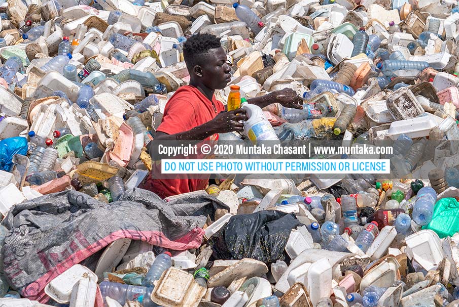 Urban poor man swims in the polluted Korle Lagoon in Accra, Ghana, to recover recyclable plastics. Plastic pollution is visible in many African countries, where municipal waste management systems are inefficient. Copyright © 2020 Muntaka Chasant