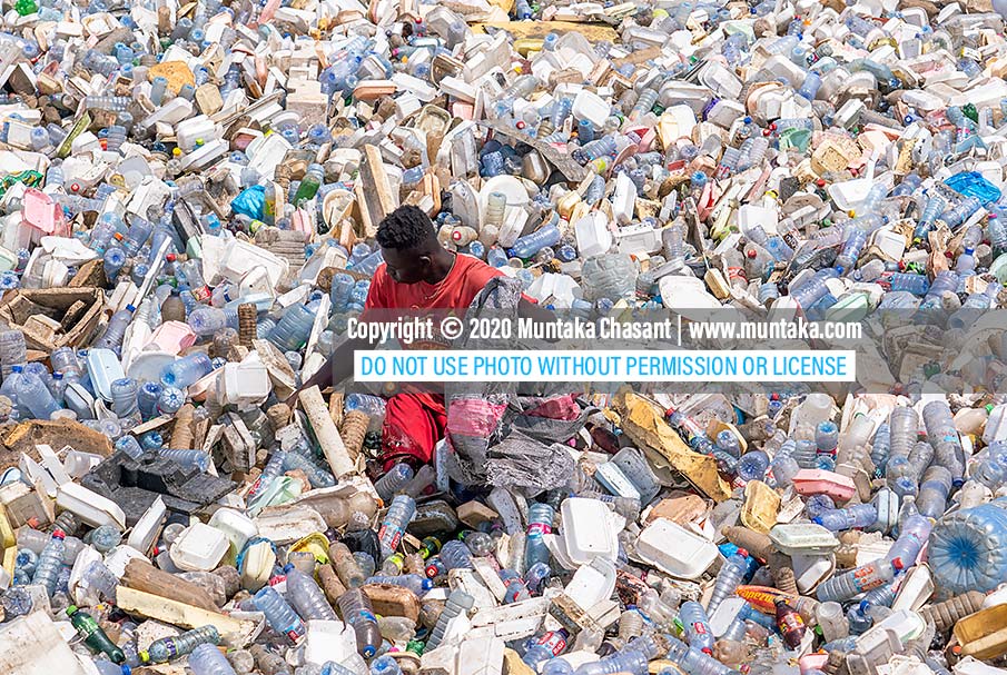 Plastic waste collectors: An urban poor Ghanaian man collects recyclable plastic waste from the polluted Korle Lagoon in Accra, Ghana. Plastic waste collectors help to reduce waste, clean up costs, and supply materials to recyclers. Copyright © 2020 Muntaka Chasant