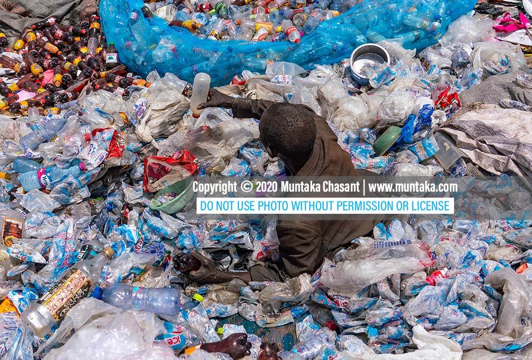 Plastic waste in Ghana: Urban poor elderly African man sorts recyclable plastics at a dumpsite in Accra, Ghana. Copyright © 2020 Muntaka Chasant