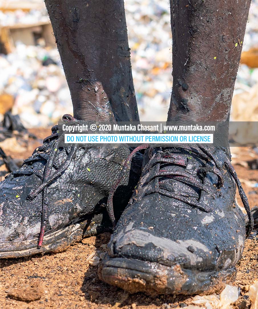 Youth poverty in Africa: Photo of a poor young African man who had to swim in the polluted Korle Lagoon in Accra, Ghana, to recover recyclable plastics before he could earn money to buy food. Around 80 million youth (15-24 years) in Africa live in extreme poverty. Copyright © 2020 Muntaka Chasant