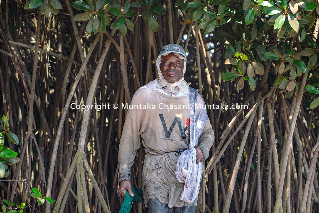 A 76-year-old urban fisherman rests under the shade of a red mangrove tree in Accra, Ghana. Copyright © 2020 Muntaka Chasant