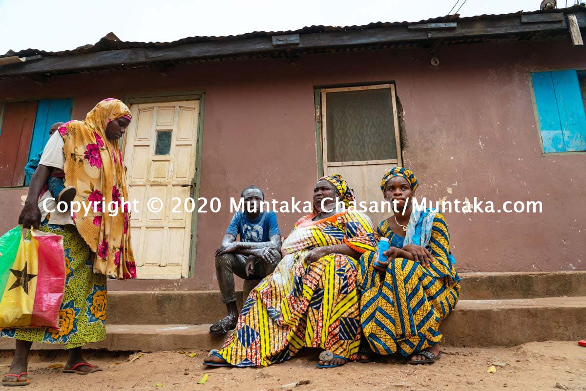 A well-wisher (holding a Ghana flag printed rubber bag) stopped by to congratulate Wasila for reuniting with Malik, her nephew. February 19, 2020. © 2020 Muntaka Chasant