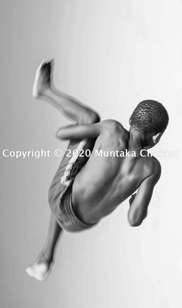Children playing: Boy doing a backflip. Copyright © 2020 Muntaka Chasant