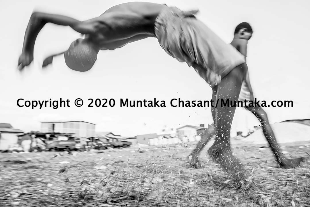 Urban poor children backflipping and landing on sawdust in the Sodom and Gomorrah slum in Accra, Ghana's capital city. Copyright © 2020 Muntaka Chasant
