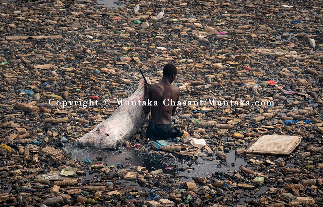 A 28 years old urban poor man recovers recyclable plastics and cans from the Korle Lagoon. Copyright © 2021 Muntaka Chasant