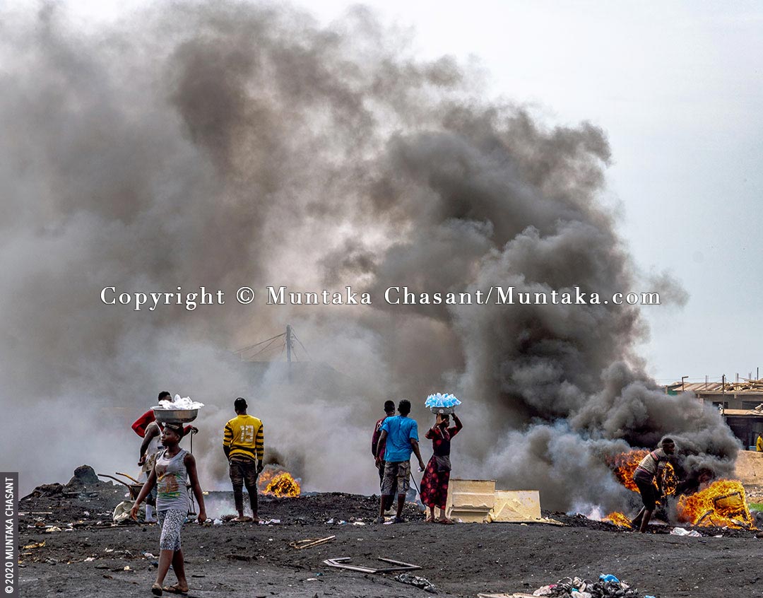 Agbogbloshie in May 2020: Young urban poor men are burning insulated wires in the open to recover the copper materials inside near the center of Accra, Ghana's capital city. © 2020 Muntaka Chasant