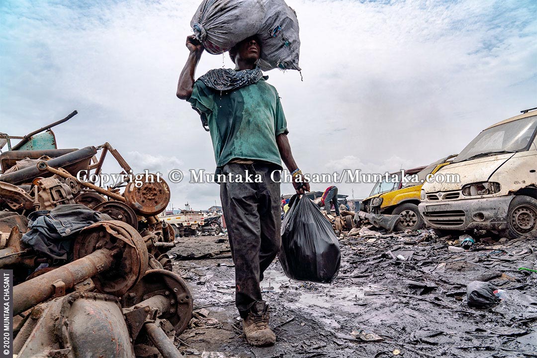 Urban Suffering: Urban poor man carries a plastic sack on his head with liquid dripping from it in Accra, Ghana. 41% of people in Africa live in extreme poverty, with the World Bank estimating that nearly 9 out of every 10 people in extreme poverty will be living on the continent by 2030. © 2020 Muntaka Chasant