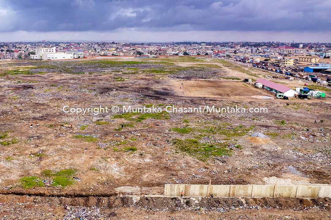 Taken on 29 August 2022, an aerial photo shows a concrete wall being built around roughly 30 hectares of land reclaimed following the demolition of the Agbogbloshie Scrapyard and nearby sites. I can confirm that no scrap dealer has relocated to the Teacher Mante site after one year. For most of the workers, the location doesn’t seem to chime with how their work is organized. I have conducted more than a year-long ethnography — findings yet to be published — following the demolition. For now, e-waste practices and end-of-life vehicle recycling remain scattered all over Accra and Tema. Copyright © Muntaka Chasant