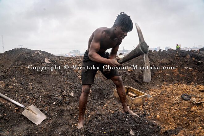 Desperate urban poor man digs deep into the surface of the demolished Agbogbloshie site to find scrap metal. Copyright © Muntaka Chasant