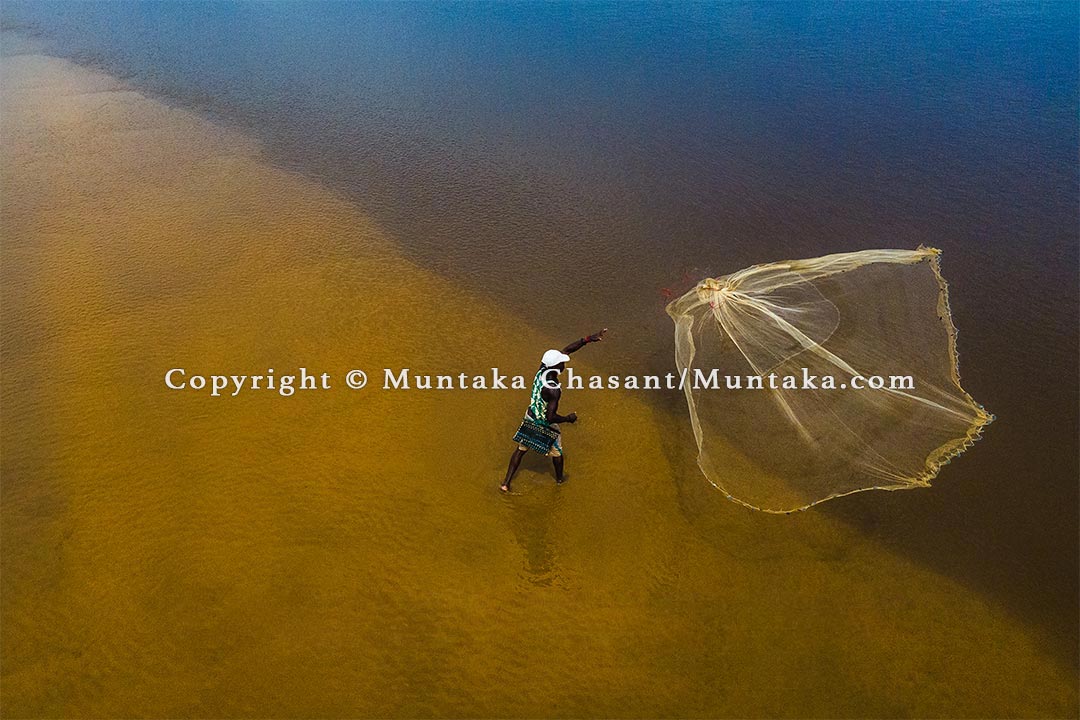 Climate change in Ghana: Fisherman casts a net over the Amisa Lagoon in Ghana. Kofi Odomna has attempted several times without a single catch. He gets zero catch when he goes out to sea. Ocean warming and factors, including 'saiko,' light and blast fishing have contributed to the increased incidence of poverty among canoe fishers in Ghana. Copyright © Muntaka Chasant