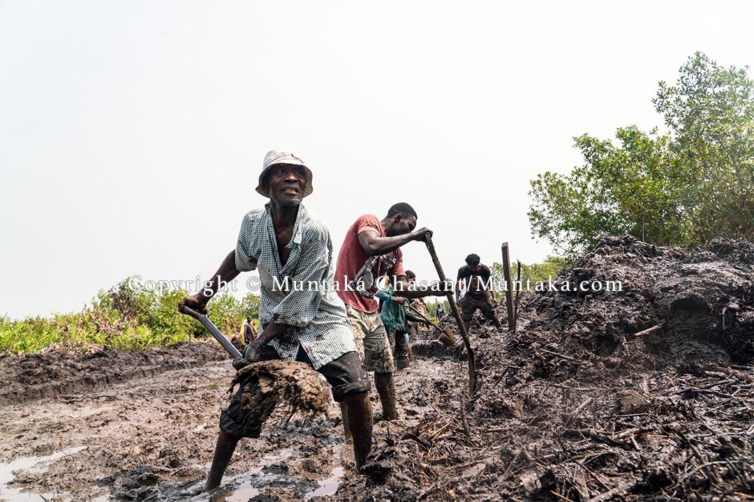 Desperate rural men use shovels and bare hands to dig in an attempt to create a channel. Copyright © Muntaka Chasant