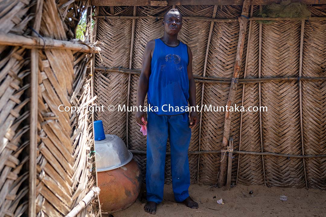 Prosper — standing behind temporary shelters — lived all his life at Fuveme until the rest of the village was swallowed by the Atlantic Ocean in 2016. Copyright © Muntaka Chasant