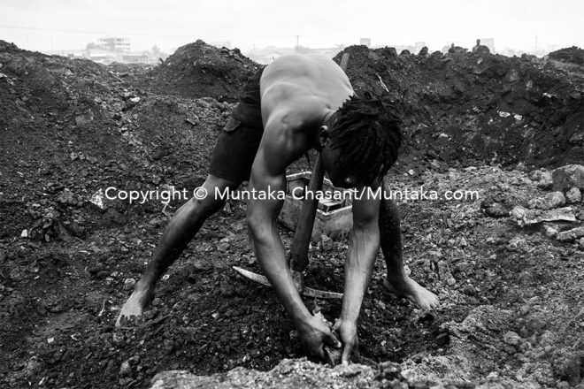 Desperate Nana finds a piece of metal after digging into the surface of the demolished site. Copyright © Muntaka Chasant