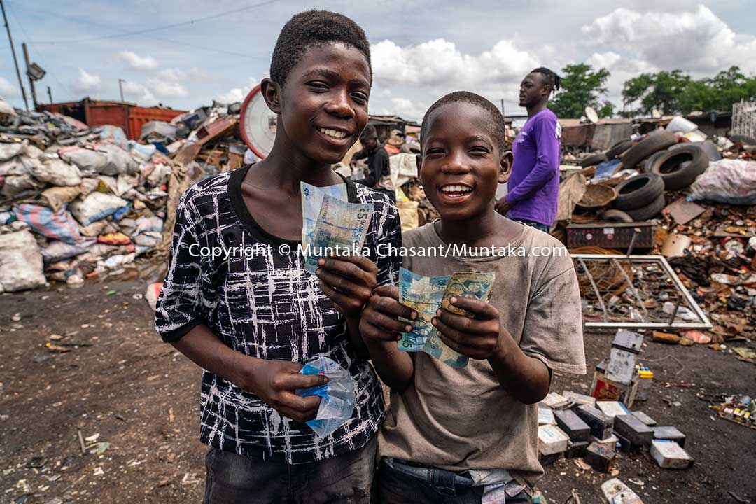 Osei and Mustafa weigh their goods. © 2020 Muntaka Chasant